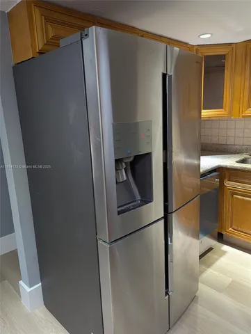 a metallic refrigerator freezer sitting in a kitchen