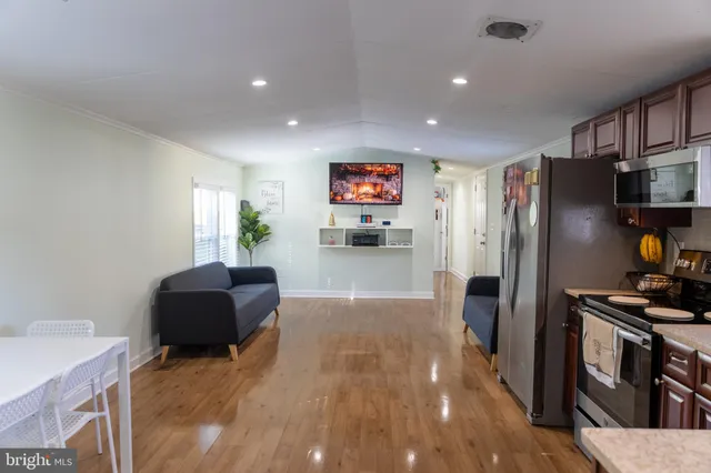 a kitchen with stainless steel appliances kitchen island granite countertop a refrigerator and a stove top oven