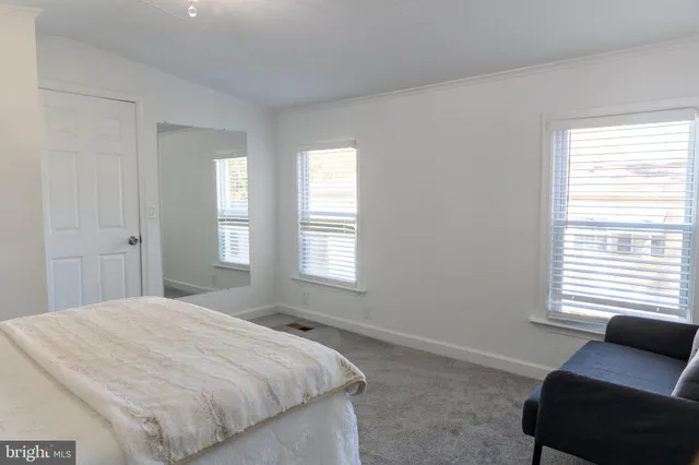a bedroom with a bed and a couch with window