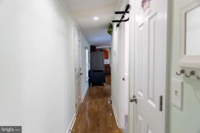 a view of a hallway with wooden floor and staircase