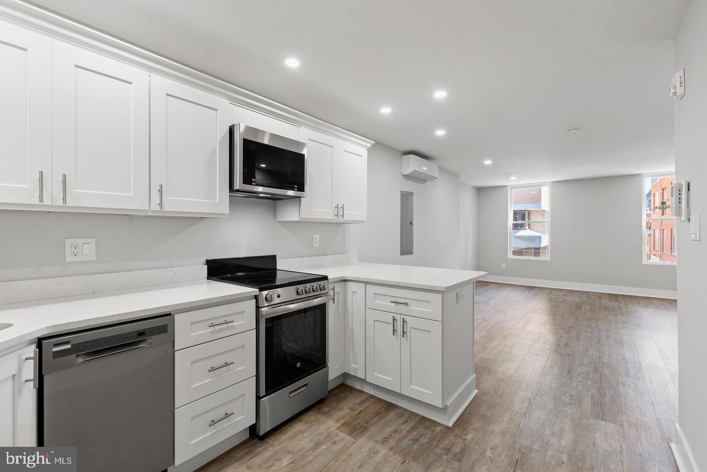 256 South 11th Street, Unit 2 Philadelphia, PA 19107 - Photo 6 of 13 a kitchen with stainless steel appliances granite countertop a stove a sink and a microwave