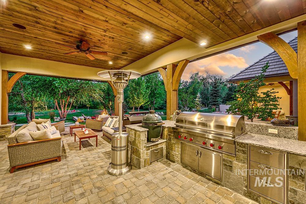 1582 East Rivers End Court Eagle, ID 83616 - Photo 17 of 49 Patio terrace at dusk featuring an outdoor hangout area, an outdoor kitchen, ceiling fan, and a patio