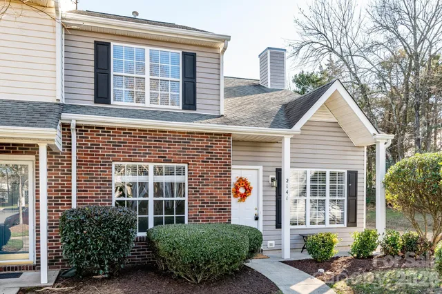 a front view of a house with a yard and potted plants