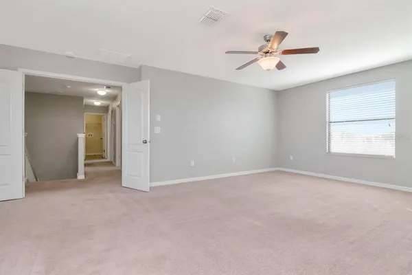 an empty room with fan and windows