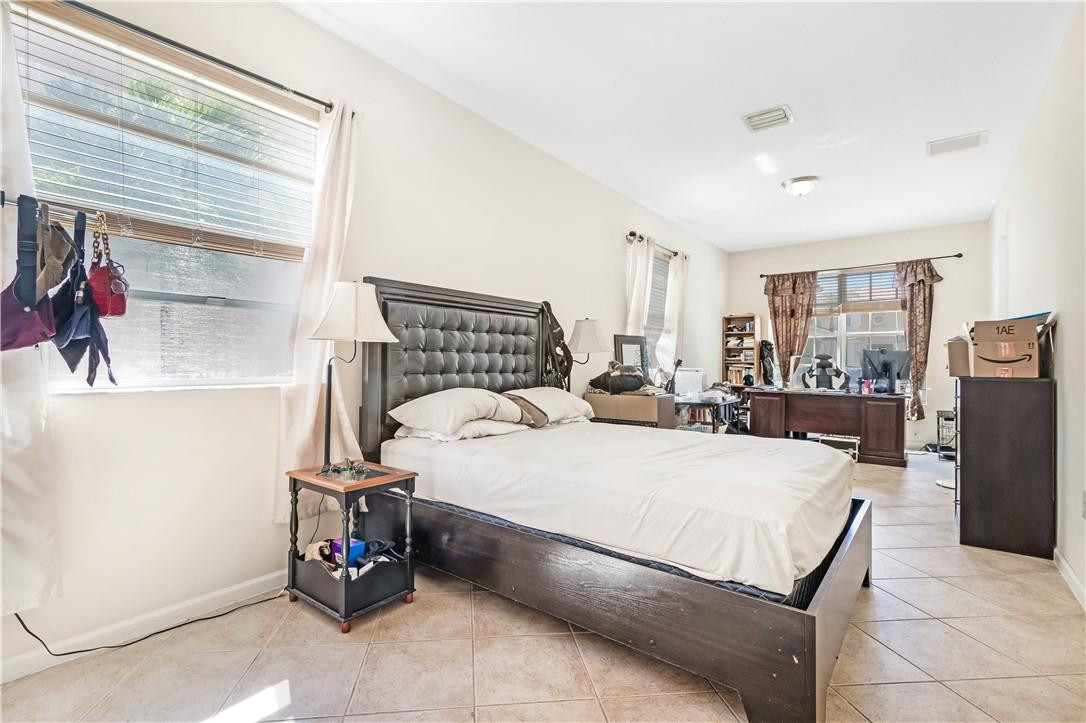 4611 Southwest 131st Terrace Miramar, FL 33027 - Photo 13 of 66 a bed room with a bed and a refrigerator