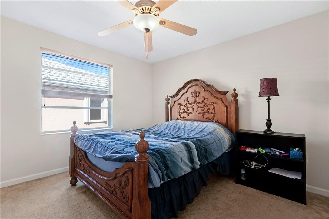 4611 Southwest 131st Terrace Miramar, FL 33027 - Photo 20 of 66 a bed sitting in a bedroom next to a window with a chandelier