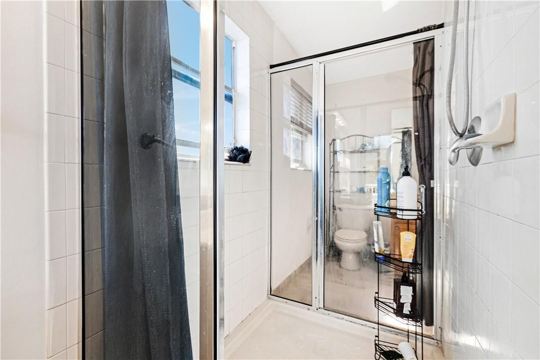 4611 Southwest 131st Terrace Miramar, FL 33027 - Photo 30 of 66 a bathroom with a glass shower door and a mirror
