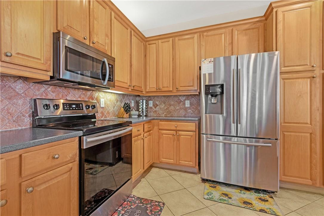 4611 Southwest 131st Terrace Miramar, FL 33027 - Photo 33 of 66 a kitchen with stainless steel appliances granite countertop a refrigerator stove and microwave