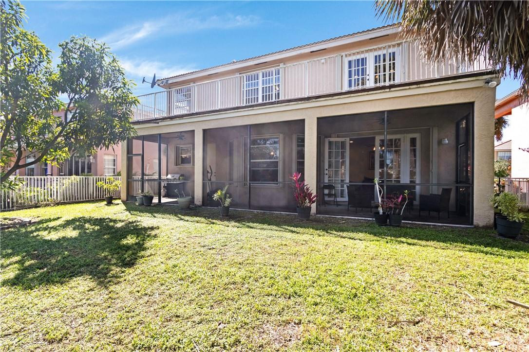4611 Southwest 131st Terrace Miramar, FL 33027 - Photo 45 of 66 a view of a house with floor to ceiling windows and a yard with wooden fence