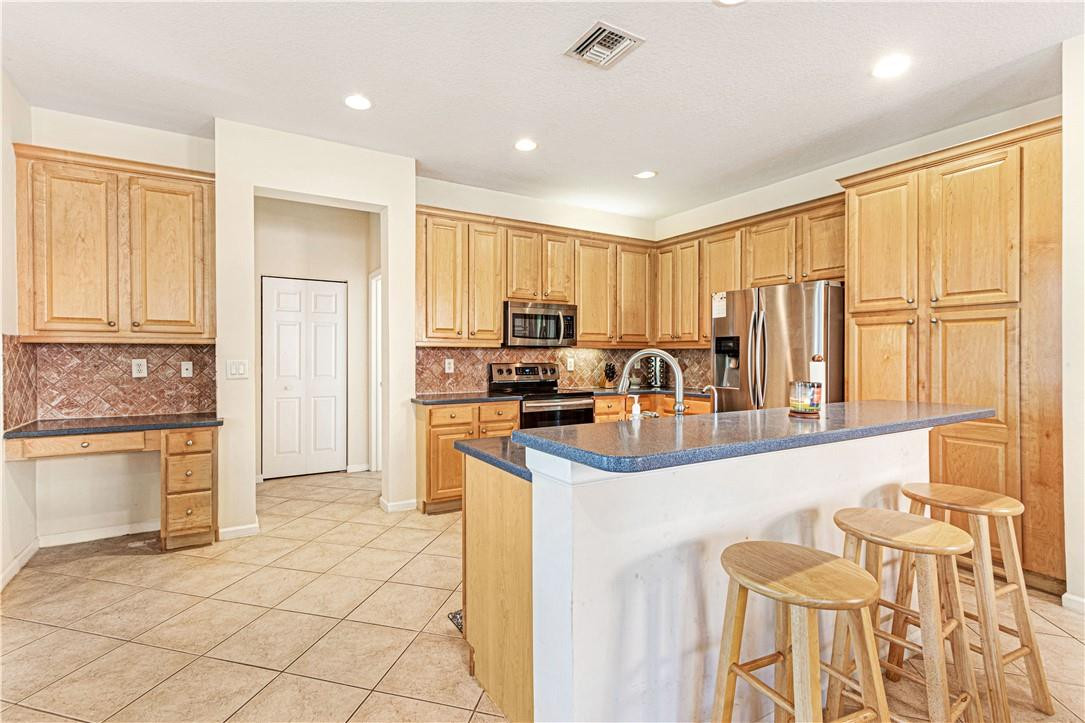 4611 Southwest 131st Terrace Miramar, FL 33027 - Photo 8 of 66 a kitchen with granite countertop a stove a sink dishwasher a refrigerator and cabinets with wooden floor