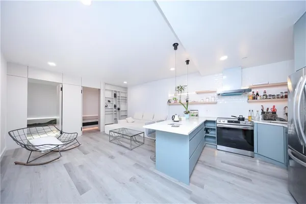 a kitchen with kitchen island a sink a stove a dining table and chairs