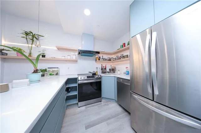 a kitchen with stainless steel appliances granite countertop a sink a stove and a refrigerator