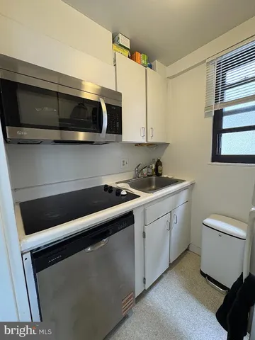 a kitchen with stainless steel appliances a stove microwave and sink