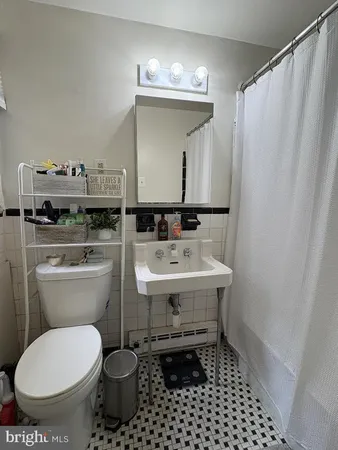 a bathroom with a toilet sink and mirror