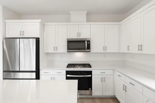 a kitchen with white cabinets and stainless steel appliances