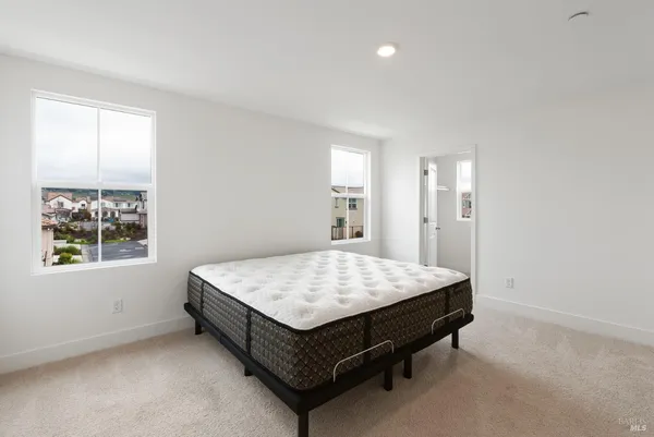 a bed sitting in a spacious bedroom next to a window