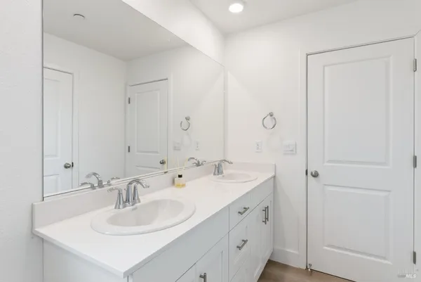 a bathroom with double sink and a mirror