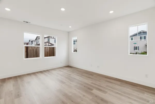 a view of a big room with wooden floor and windows