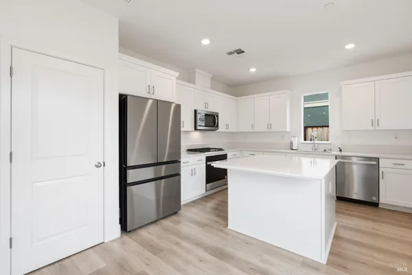 a kitchen with a refrigerator sink and cabinets