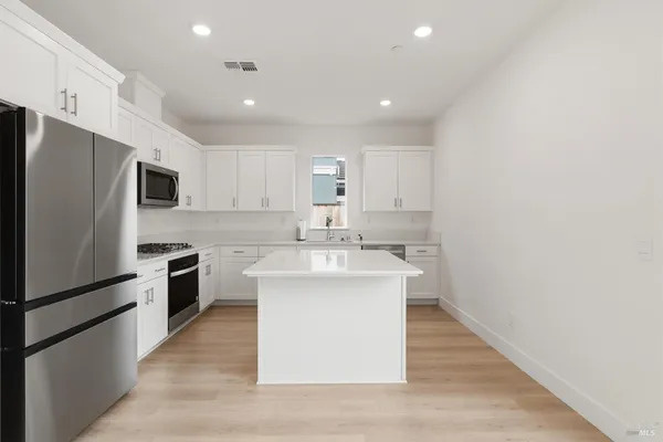 a kitchen with stainless steel appliances a sink stove and refrigerator