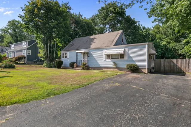 a view of a house with backyard and tree s