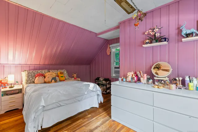 a bedroom with a bed and a dresser with mirror