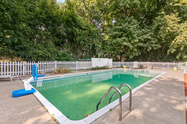 a view of a swimming pool with a patio and a garden