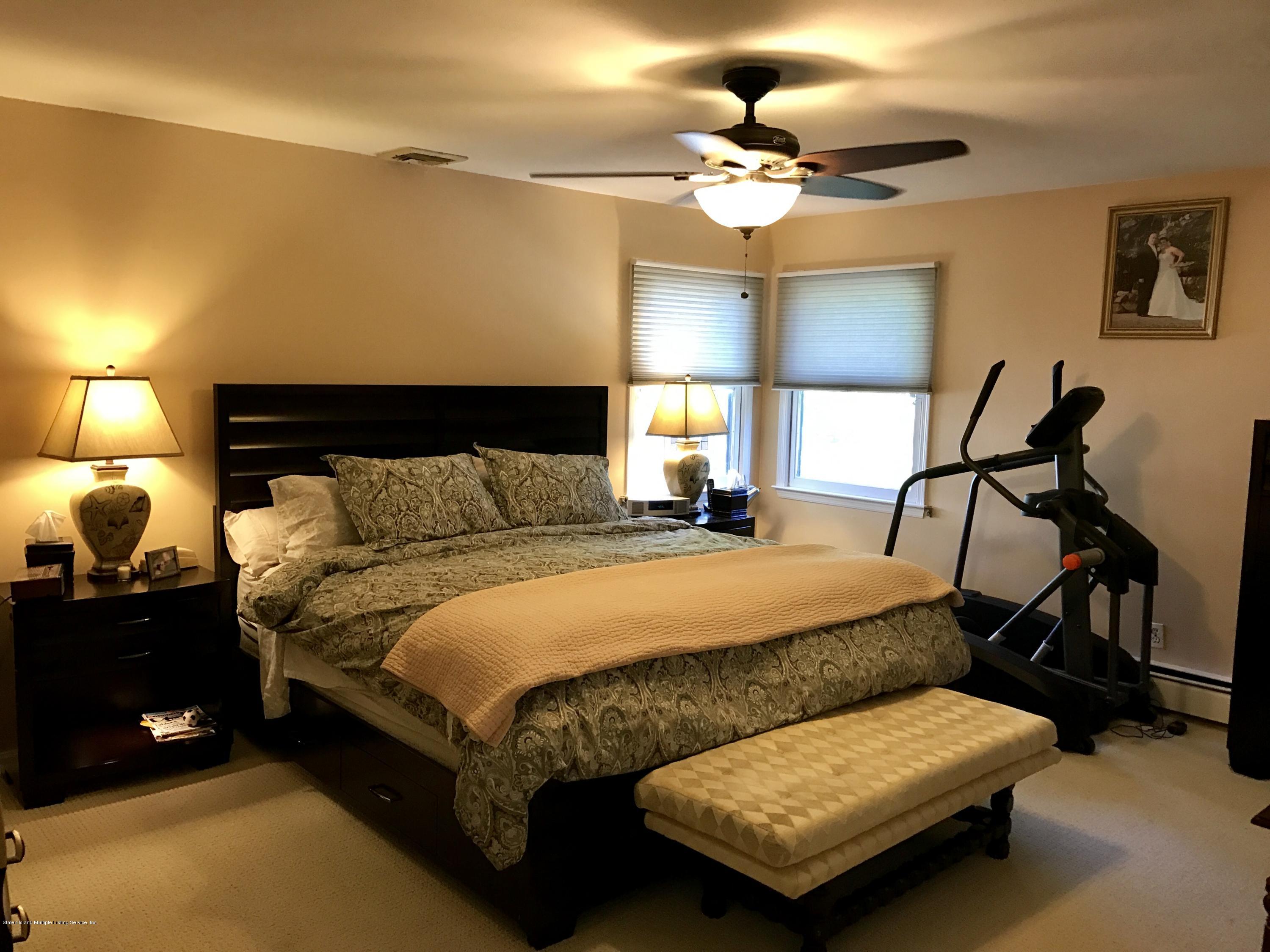 80 Rathbun Avenue Staten Island, NY 10312 - Photo 15 of 21 a bedroom with a bed a lamp and a chandelier