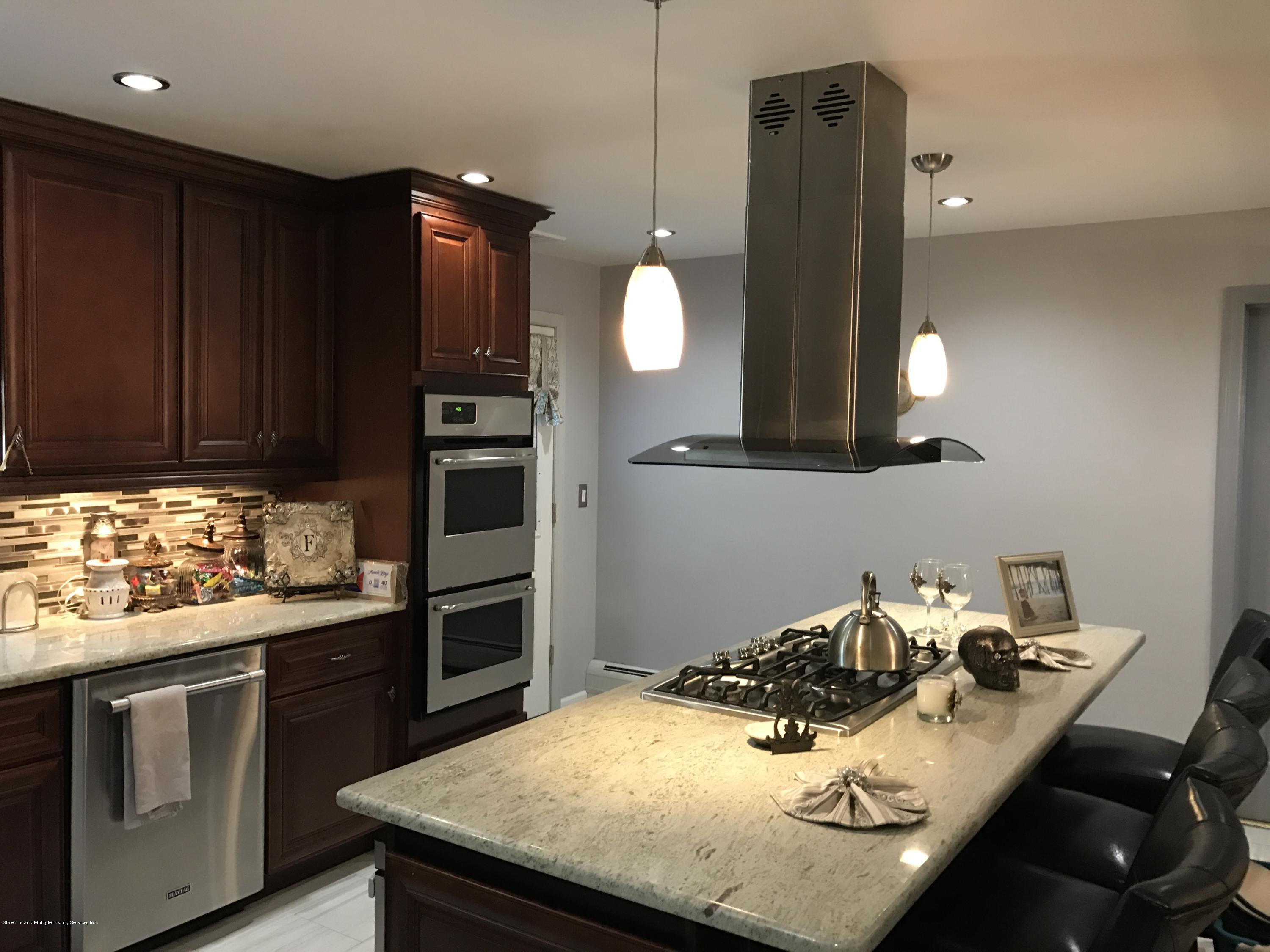 80 Rathbun Avenue Staten Island, NY 10312 - Photo 4 of 21 a kitchen with kitchen island a stove and a sink with cabinets