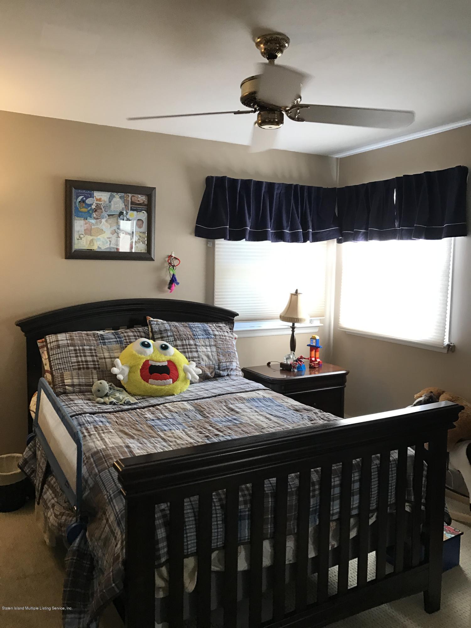 80 Rathbun Avenue Staten Island, NY 10312 - Photo 10 of 21 a bedroom with a bed a dresser and potted plant