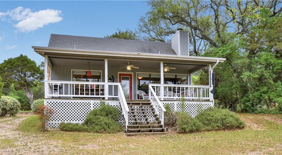 Front of lake house facing large yard and lake