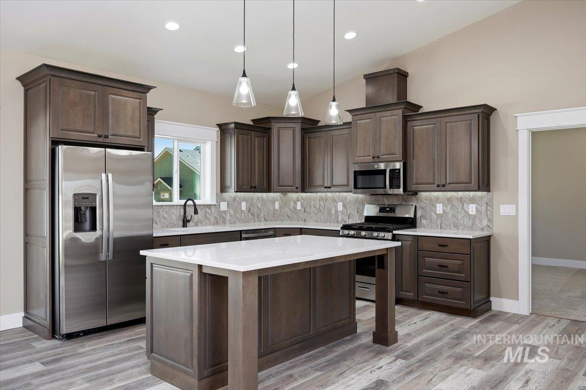 231 Sandi Road Twin Falls, ID 83301 - Photo 8 of 31 Kitchen featuring stainless steel appliances, dark brown cabinets, decorative light fixtures, a kitchen island, and recessed lighting