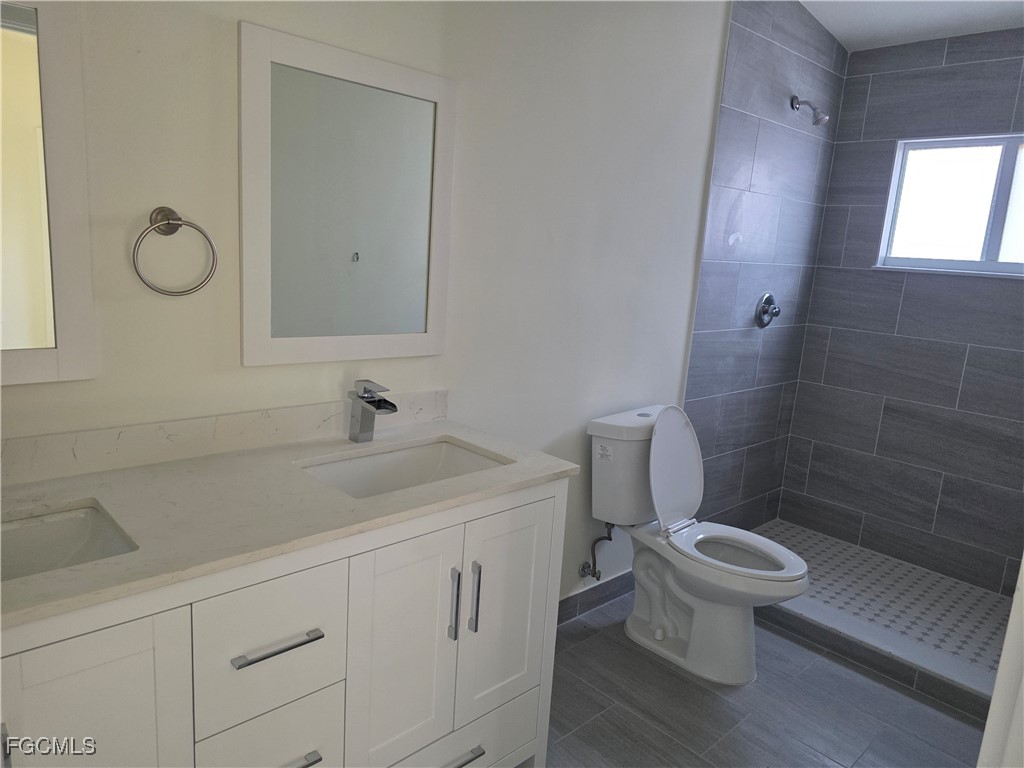2615 32nd Street Southwest Lehigh Acres, FL 33976 - Photo 13 of 19 a bathroom with a sink a toilet and shower