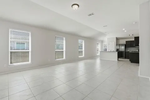 a view of an empty room with a kitchen