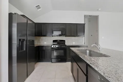 a kitchen with a sink stove and refrigerator