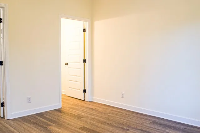 a view of an empty room with wooden floor