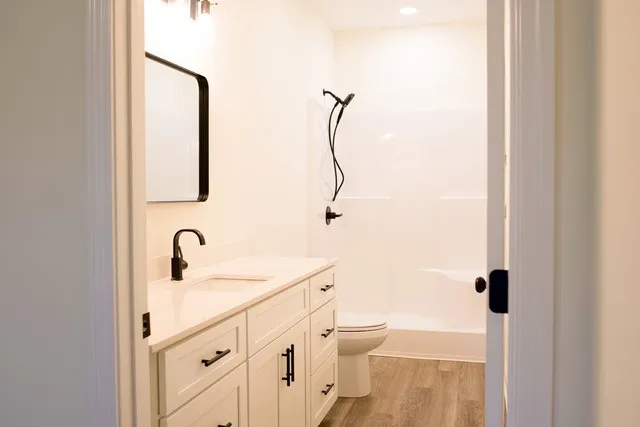 a bathroom with a sink a toilet and shower