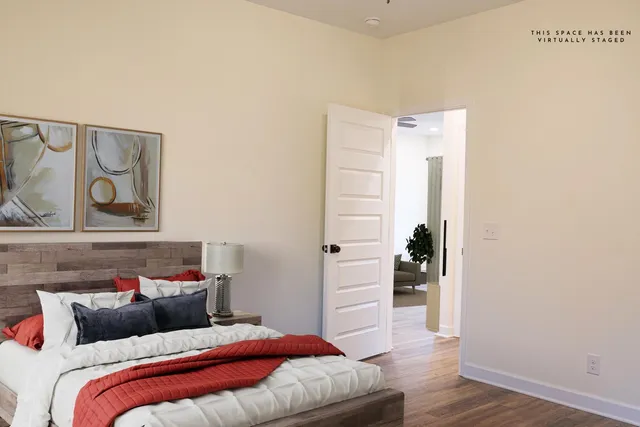 a bedroom with a bed and wooden floor