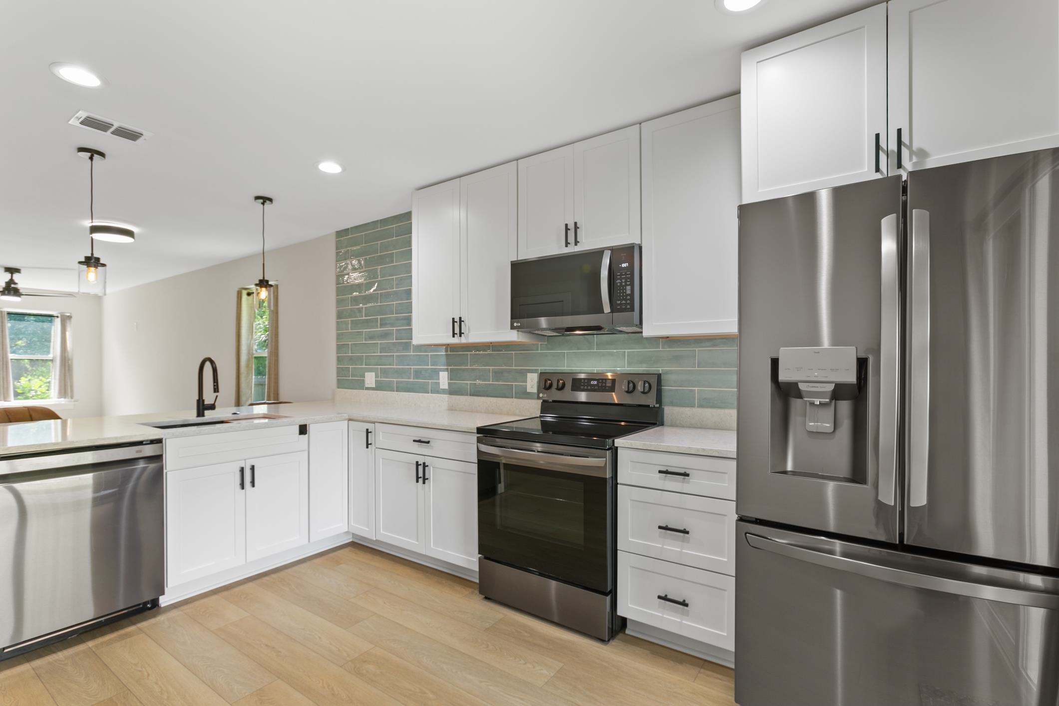 16 Sidney Street St. Augustine, FL 32084 - Photo 12 of 19 a kitchen with white cabinets and stainless steel appliances