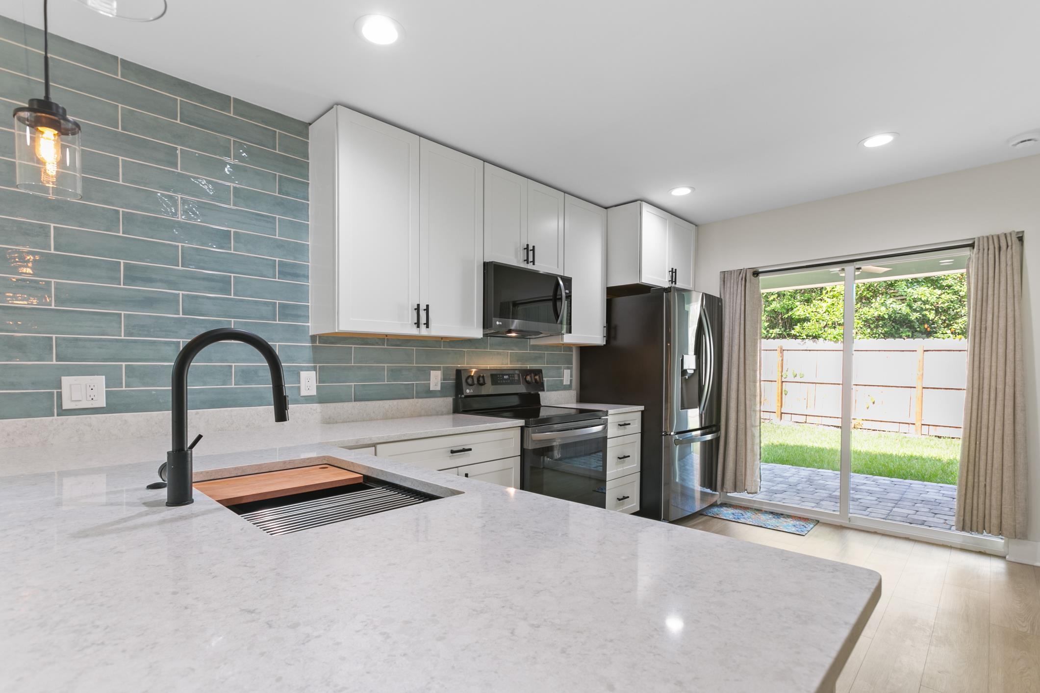 16 Sidney Street St. Augustine, FL 32084 - Photo 10 of 19 a kitchen with granite countertop a refrigerator and a stove top oven