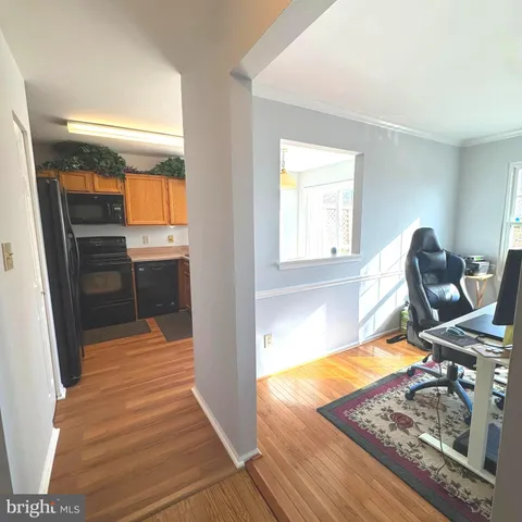 a view of a kitchen with furniture and wooden floor