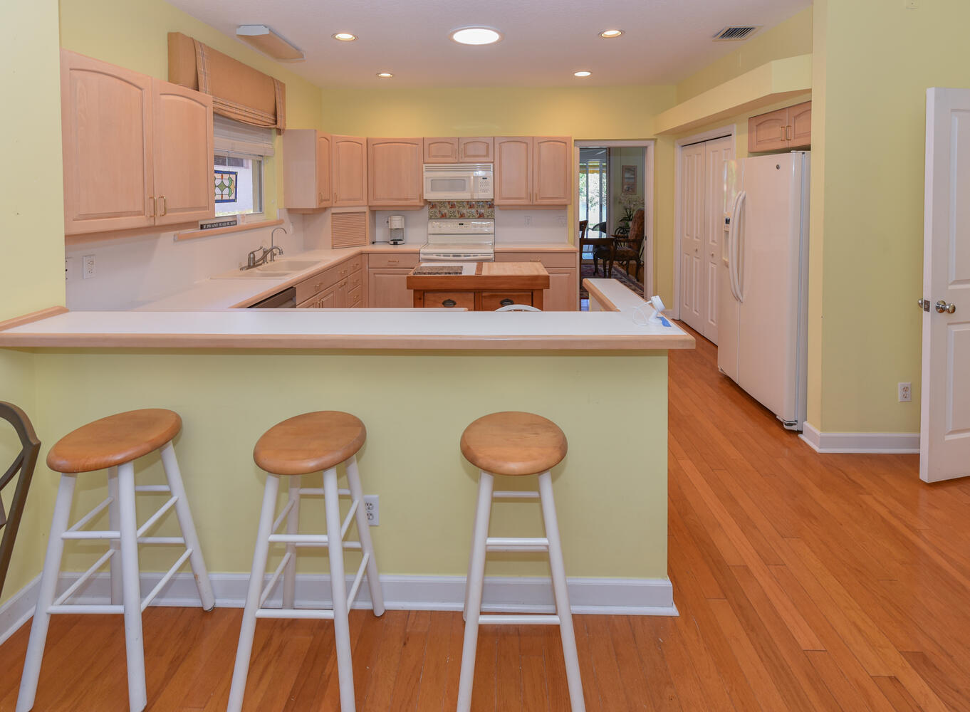 3510 Southeast Cambridge Drive Stuart, FL 34997 - Photo 19 of 54 a kitchen with a table chairs refrigerator and microwave