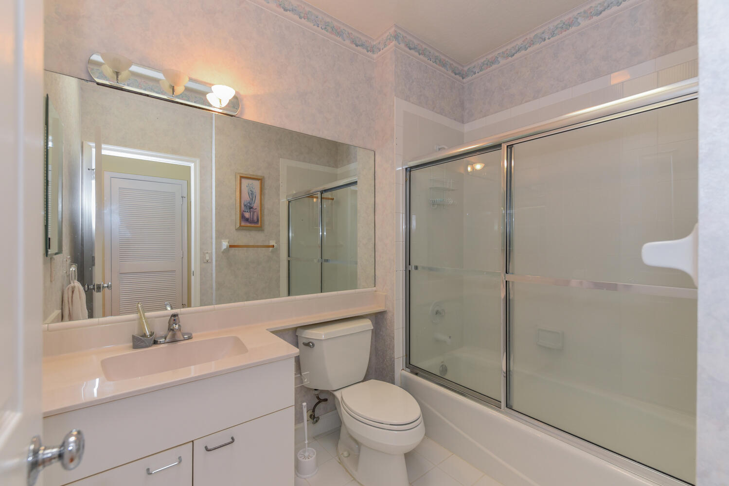 3510 Southeast Cambridge Drive Stuart, FL 34997 - Photo 33 of 54 a bathroom with a shower sink vanity mirror and toilet