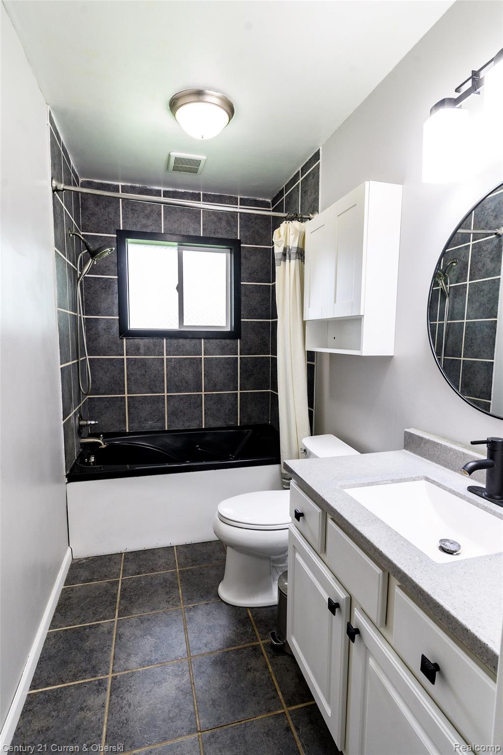 5260 Rives Junction Road Jackson, MI 49201 - Photo 22 of 44 Bathroom featuring a white vanity with a light-toned countertop, an undermount sink, and dark hardware