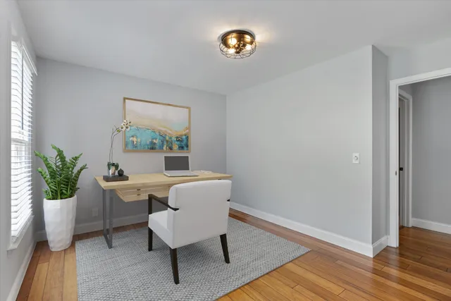 a view of a room with wooden floor and potted plant