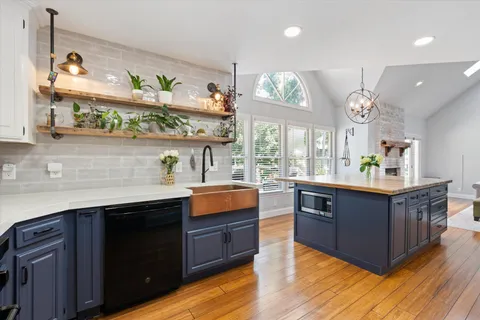 a view of a hallway with wooden floor and staircase
