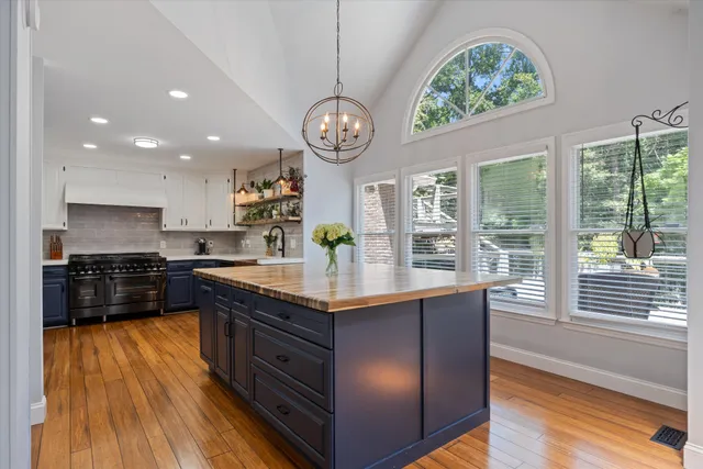 a kitchen with stainless steel appliances granite countertop a stove and a large window