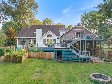 a front view of a house with a yard and trees