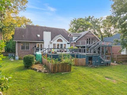 a aerial view of a house with a big yard and potted plants and large trees