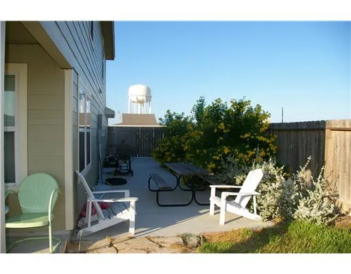 a backyard of a house with table and chairs